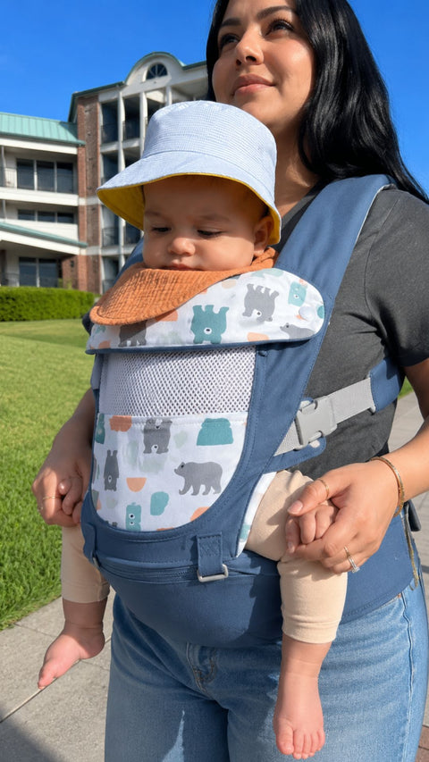 A baby in a sun hat riding in Grow+
